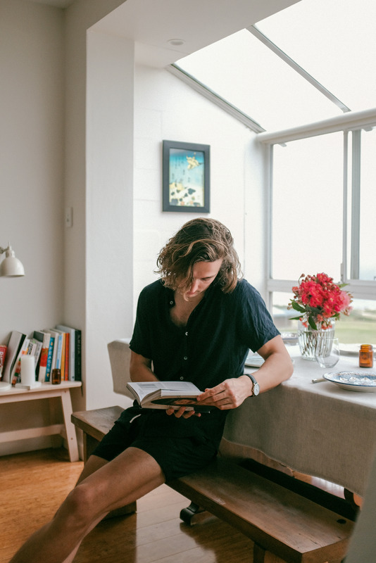 Man-Reading-Book-While-Sitting-On-Bench